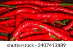 Small photo of Vibrant red trails of curly chili up close. The fiery hue exudes a captivating visual, hinting at warmth and a spicy flavor ready to tantalize the taste buds. #ChiliPepper #FieryRed #Spicy