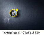 Small photo of Yellow cup, mug of black coffee with clockwise stir flat lay on scrathed rough black background. Copy space for your text, image or message. Minimal, horizontal image style.