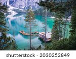Boathouse and wooden boats at Braies or Pragser Wildsee during sunset pink light. Dolomites, Italy