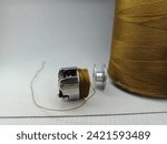 Small photo of metal bobbin case , silver bobbin case with thread