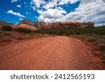 Small photo of ATV riding on the Outlaw Trail in Sedona, Arizona. The scenery has dark blue skies, rough trails, and red rocks.