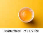 White egg and egg yolk on the yellow background.