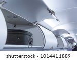 Luggage shelf with luggage in an airplane. Aircraft interior. Travel concept.