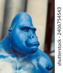 Small photo of A blue gorilla looks into the distance as he ponders why he is such an unnatural colour.