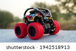 Small photo of Red black RC Truck closeup with blurred background. Monster big toy with attractive stylish design and spring suspension shocker.