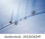 winter road in snow covered fields, top down aerial view, landscape covered by snow and trees with morning shadow. Simplicity concept landscape