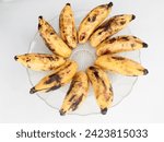 Small photo of Close-up view of an almost rotten bananas with brown and blackish skin texture.