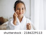Cute girl applying face cream