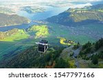 An open air cable car on Stanserhorn, Switzerland with lake Luzern in the background.