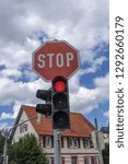 Small photo of Stop sign over a red traffic light