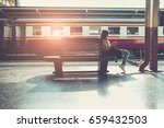 Asian hipster lady photographer sitting at subway station waiting for train. Traveler backpacker girl. Young Woman at platform train railway traveling.  Asian lady hipster photographer sit at subway.