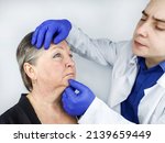 Small photo of An elderly woman at a plastic surgeon's consultation regarding the elimination of age-related wrinkles. Gubo-chin folds, lowered corners of the mouth. Correction of the lower third of the face.