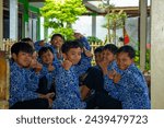 Small photo of Indonesia, March 15, 2024 - a children say hallo and gave respect for a world, smile and fun with education