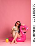 Small photo of beautiful young woman in bikini with big pink flamingo toy, isolated on pink background. blond girl smiling, posing with beach accessorize . beach summer concept, tropical vibe, studio shot