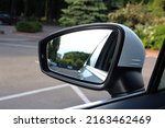 Rear view mirror car on the road. Rearview mirror with reflection in it. Accessory for vehicles to look back on road for good visibility and drive car safely. Wing mirror of a Car with nature street.