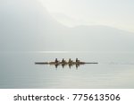 Four rowers on boat floating on sunny morning on background of mountains on lake of Lugano. Concept of healthy lifestyle, water sports. Switzerland.