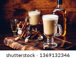 Small photo of Coffee with Irish whiskey and whipped cream in glass on rustic wooden surface