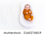 Small photo of The baby is lying in a cocoon of copy space . The baby is 0-3 months old. A contented infant. An article about choosing a cocoon for newborns. An article about the benefits of cocoon. An article about