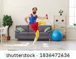 Small photo of Happy goofy young man in retro sportswear decided to start fitness training and now is exercising with dumbbells and laughing, motivating you to do sports, keep fit and lead healthy lifestyle too