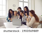 Small photo of Happy excited business women looking at laptop computer, cheering and shouting for joy. Team of jubilant lucky young workers celebrating successful project realization, making deal or signing contract
