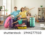 Small photo of Portrait of happy family all set to leave on travel vacation. Smiling mom, dad and little kids ready for holiday trip spread arms in airplane wings gesture pretending to fly like a plane at home