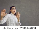 Small photo of Yuck. Scared woman with expression of fear, fright and disgust on face asking you to stop. Young lady on grey studio background afraid of something dangerous or repulsive doing protective hand gesture