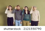 Small photo of Four adult people gasp in surprise and take off glasses shocked by something extraordinary. Group of 4 young and old people standing in line and looking at something with astonished face expressions