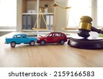 Small photo of Two small cars on table in courtroom. Gavel and little toy car models on desk in courthouse. Road crash, law, justice, lawyer services, civil trial, accident case study, insurance coverage concept