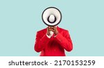 Small photo of Dark-skinned man hiding his face behind loudspeaker makes loud advertisement on pastel light blue background. Unknown man in red elegant jacket loudly announces crazy discounts. Advertisement concept.