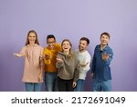Small photo of Diverse group of happy cheerful young multiethnic people standing together, looking at the camera, smiling, extending their hands and doing an inviting gesture, telling you 'Come here and join us'