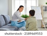 Small photo of Professional psychologist working with a school child. Therapist or school counselor trying to support a depressed little boy and help him cope with his problems. Children's psychology concept
