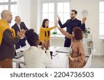 Small photo of Happy business team celebrating their well deserved success. Group of joyful elated excited smiling people applauding and high fiving each other during a work meeting in the office. Teamwork concept