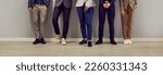 Small photo of Business team standing in office. Diverse group of unrecognizable men and women in smart casual clothes of restrained colors standing by office wall. Cropped shot, people's legs. Banner background