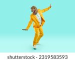 Small photo of Happy man in dinosaur disguise skateboarding and having fun. Full length body portrait joyful man wearing bright yellow suit and funny reptile mask riding on pretend skateboard on turquoise background