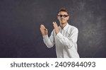 Small photo of Happy man in thug life glasses dancing isolated on text copy space background. Portrait of cheerful positive young guy in meme sunglasses having fun. College student in funny specs vibing to music