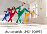 Small photo of Vibrant group of a dancing people in colorful business suits, smiling as they dance energetically. The lively atmosphere and upbeat music create a joyous dance party with a happy crowd of dancers.