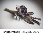 Pair of wedding boutonnieres on a white table.