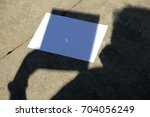 Small photo of Solar Eclipse 2017. A man uses a pin hole in a sheet of paper to photograph the Solar Eclipse on September 21, 2017. Shadow with solar eclipse example