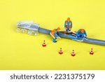Small photo of Conceptual image of miniature figure workmen investigating a fault on a broadband network cable
