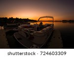 Lake sunset featuring docked pontoon boat
