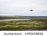 Flying saucer UFO over tundra in the Kola Peninsula in Russia. UFO floating above tundra landscape near Teriberka village