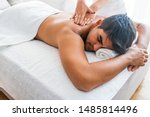 Small photo of Man having massage in spa salon, closeup. Sports massage. Massage therapist massaging shoulders of a male athlete, working with Trapezius muscle. Young Man Enjoying Massage At Spa