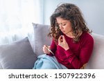 Young woman sick with colds and flu, self-medication at home with vitamins and pills. suffering from the nose due to allergies. Woman having high fever and suffering from strong headache during flu