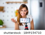 Young woman recording her vlog about healthy eating and nutritional supplements, close-up on a phone screen. Preventive medicine and influencer marketing concept