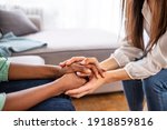 Small photo of Close-up of psychiatrist hands together holding palm of her patient. Hands of woman reassuring her colleague. Diverse women. African american family couple holding hands