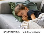 Small photo of Unhealthy little boy child measure high temperature with thermometer sleep in bed relax at home in bedroom. Sick ill little kid suffer from flu fever asleep in bed on lockdown quarantine.