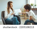 Small photo of Child psychologist working with kid boy in office. Young Boy With Problems Talking With Counselor At Home. Woman social worker talking to boy. Child psychology, mental health.