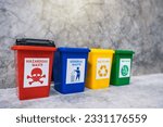 Small photo of The concept of waste classification for recycling. Collection of bins for different types of garbage by separation according to the color of the bin with old wall background.