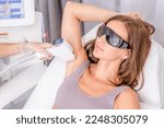 Professional beautician removes hair on armpit using a laser. Armpit hair removal with laser,  procedure at clinic