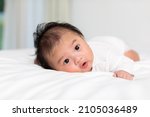 Small photo of Newborn baby 3 month laying on stomach developing neck control .tummy time for strengthen baby neck and shoulder muscles.Cute infant lying crawling on white bed happiness and fun.Tummy Time Concept